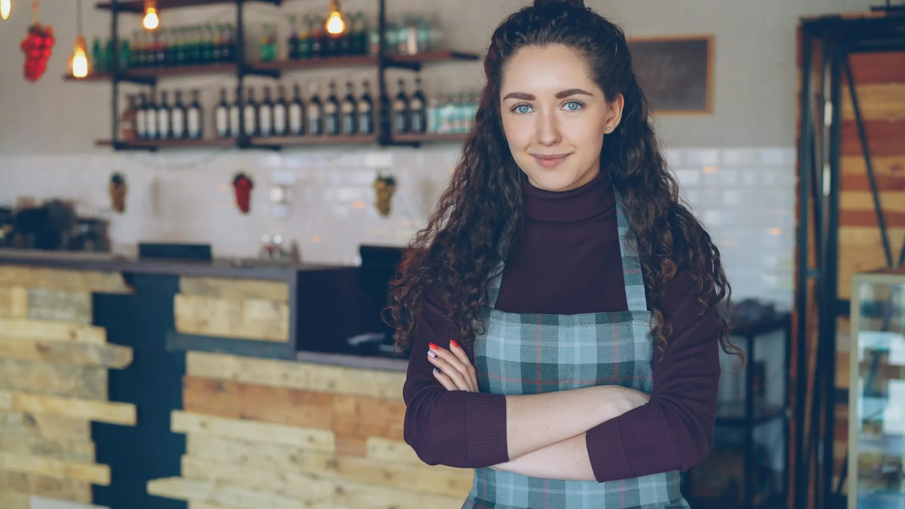 A café owner standing in her coffee shop