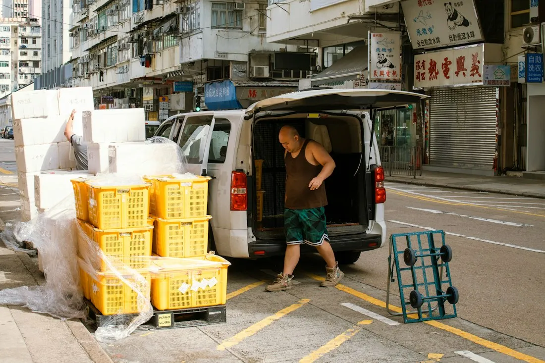 A driver unloading crates from a van
